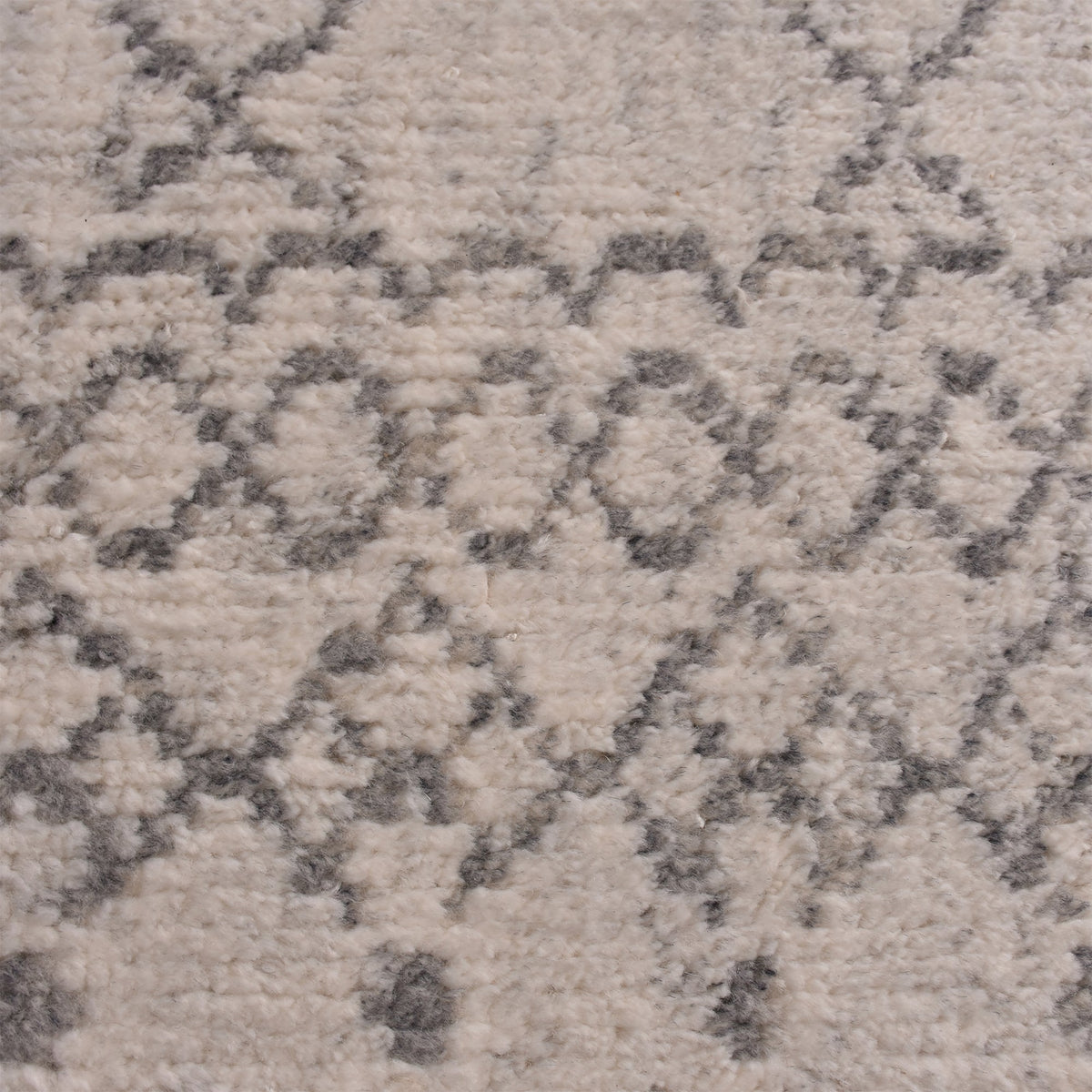 Phatak hand-knotted wool rug with an ivory diamond lattice and grey border, in a dining room