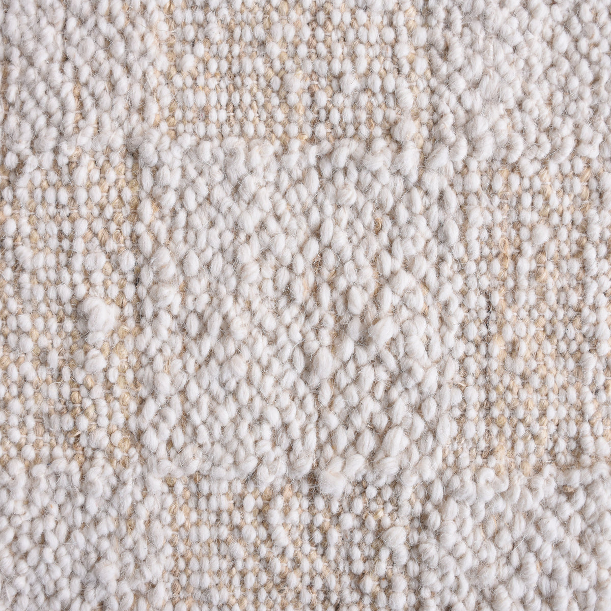 Chaupar handwoven wool and jute rug in greige and ivory with a checkerboard patch texture, in a study
