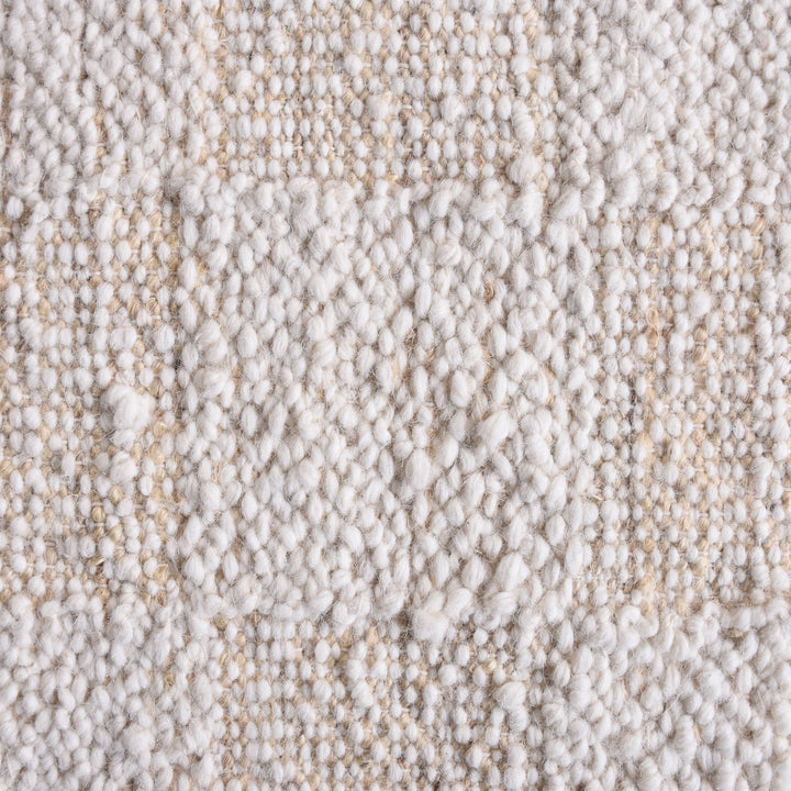 Chaupar handwoven wool and jute rug in greige and ivory with a checkerboard patch texture, in a study