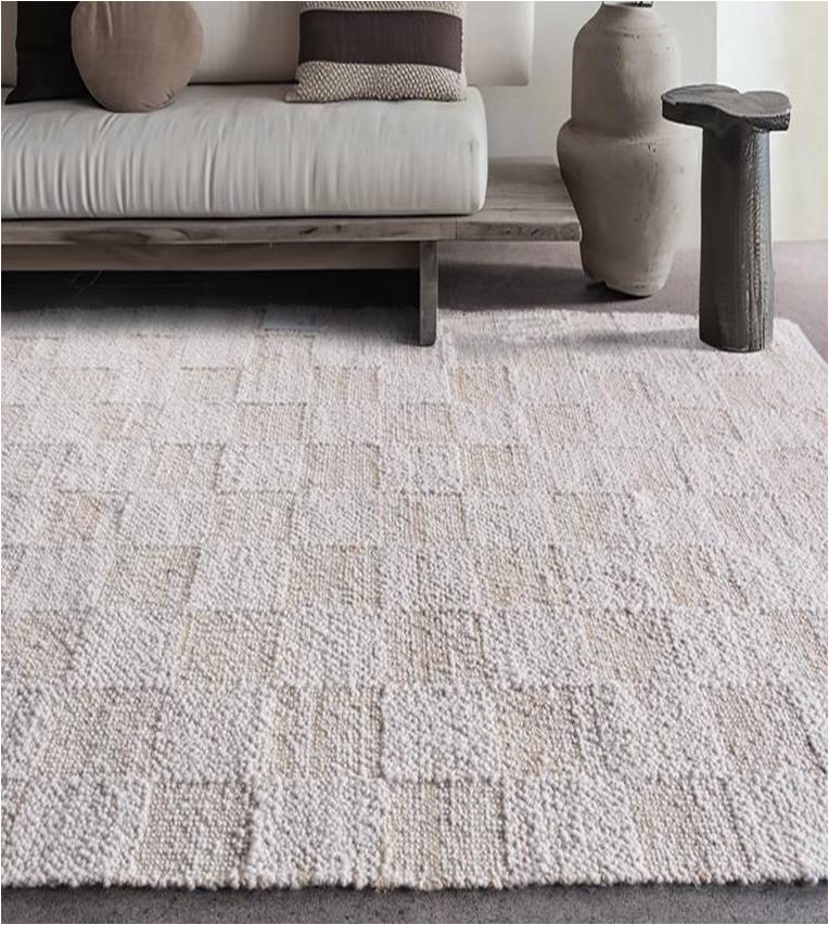 Chaupar handwoven wool and jute rug in greige and ivory with a checkerboard patch texture, in a study