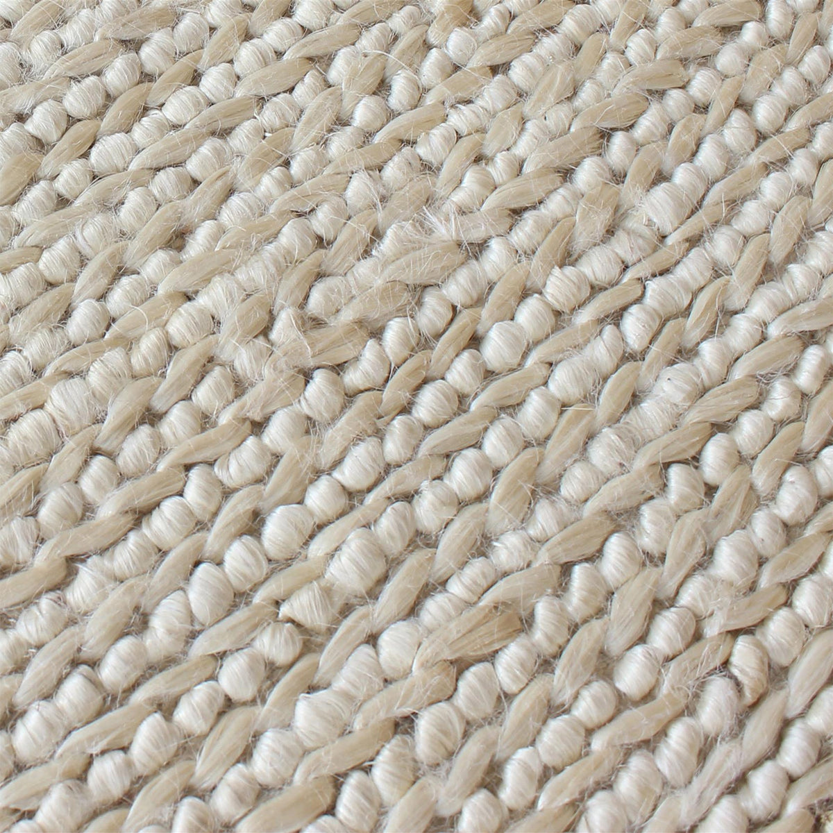 Kai handwoven hemp rug in natural with a sage cast and a tight chunky weave, in a living room
