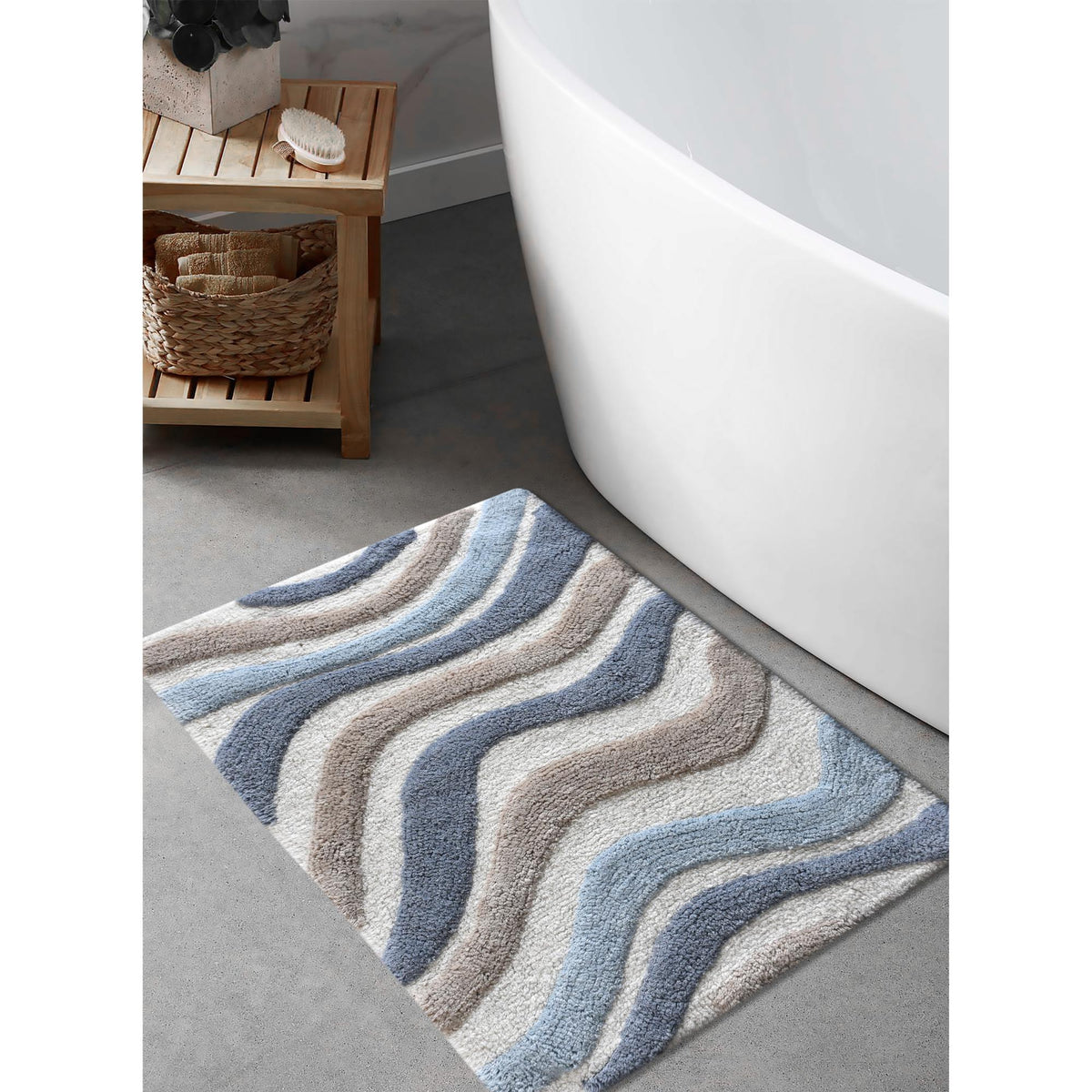 Blue Current Cotton Bath Rug — Blue, ivory and beige bands follow a gently flowing wave pattern.