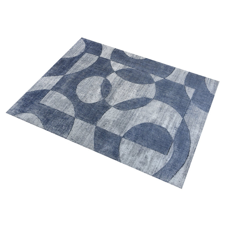 Mauj handwoven viscose and PET rug with denim blue overlapping circles on grey, in a living room