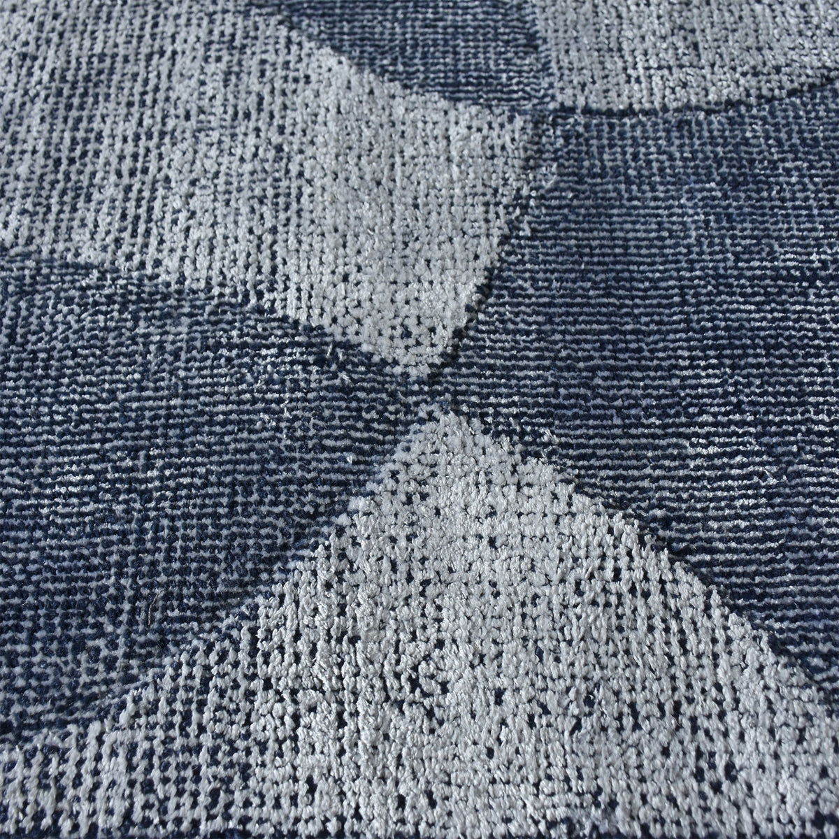 Mauj handwoven viscose and PET rug with denim blue overlapping circles on grey, in a living room