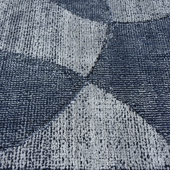Mauj handwoven viscose and PET rug with denim blue overlapping circles on grey, in a living room