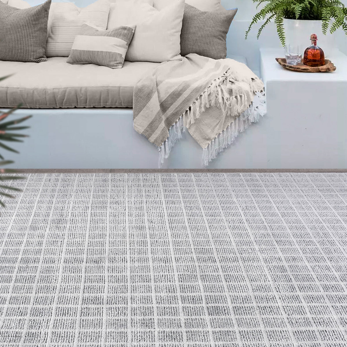 Baramda hand-loomed recycled PET rug with fine white grid lines on pale grey, on a verandah