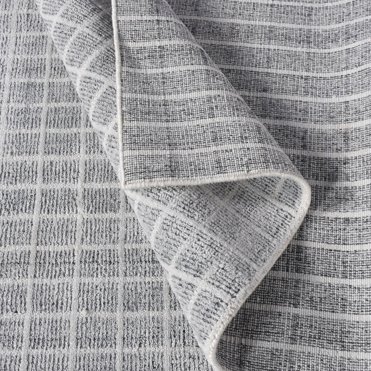 Baramda hand-loomed recycled PET rug with fine white grid lines on pale grey, on a verandah