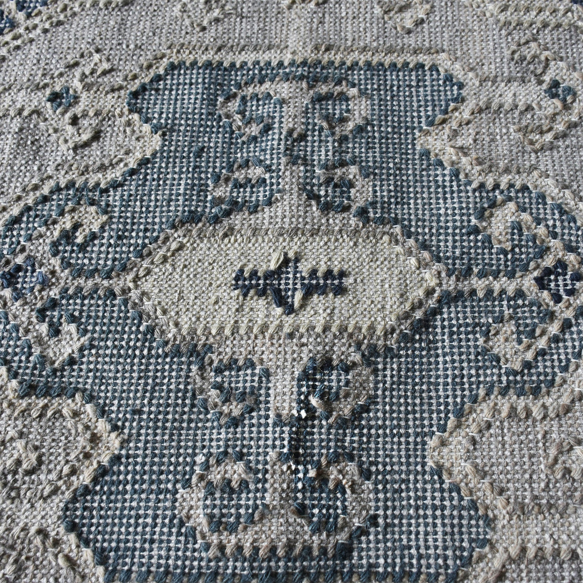 Courtyard flatweave slate blue recycled PET rug with an ivory Heriz medallion, on a patio