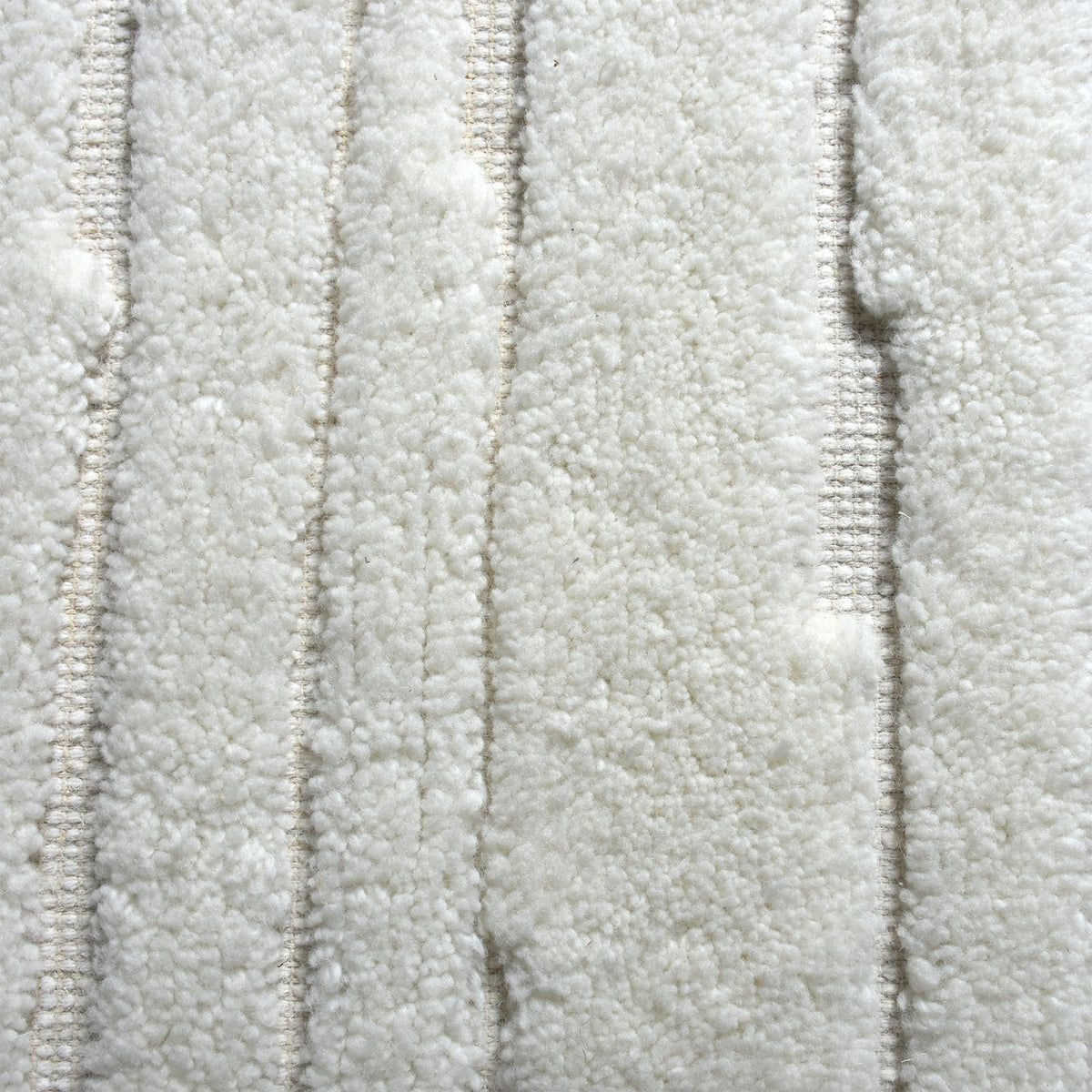 Bark handwoven ivory wool rug with carved vertical ridges, in a living room