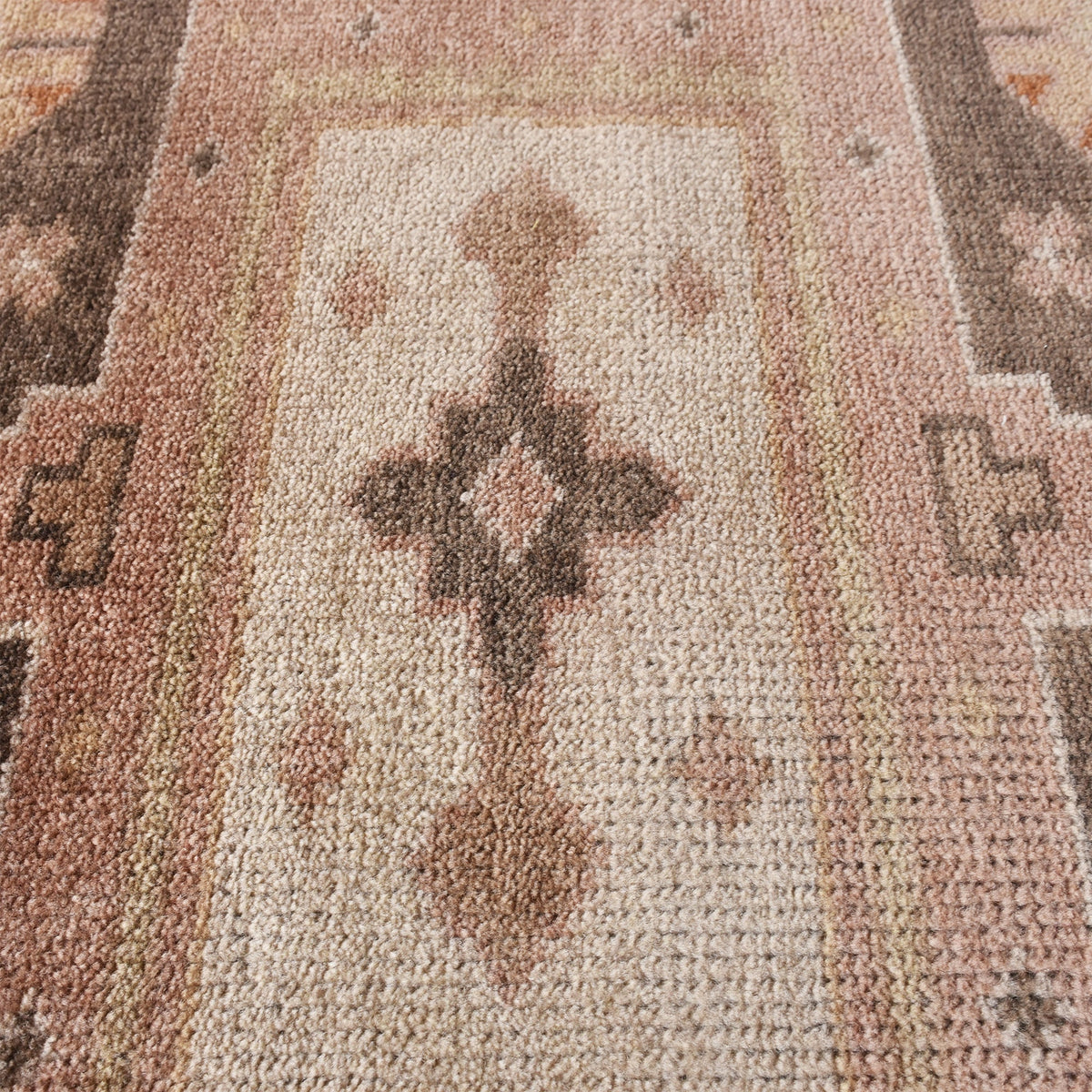 Matka hand-knotted wool rug with a faded terracotta Persian medallion, navy and brown, in a bedroom