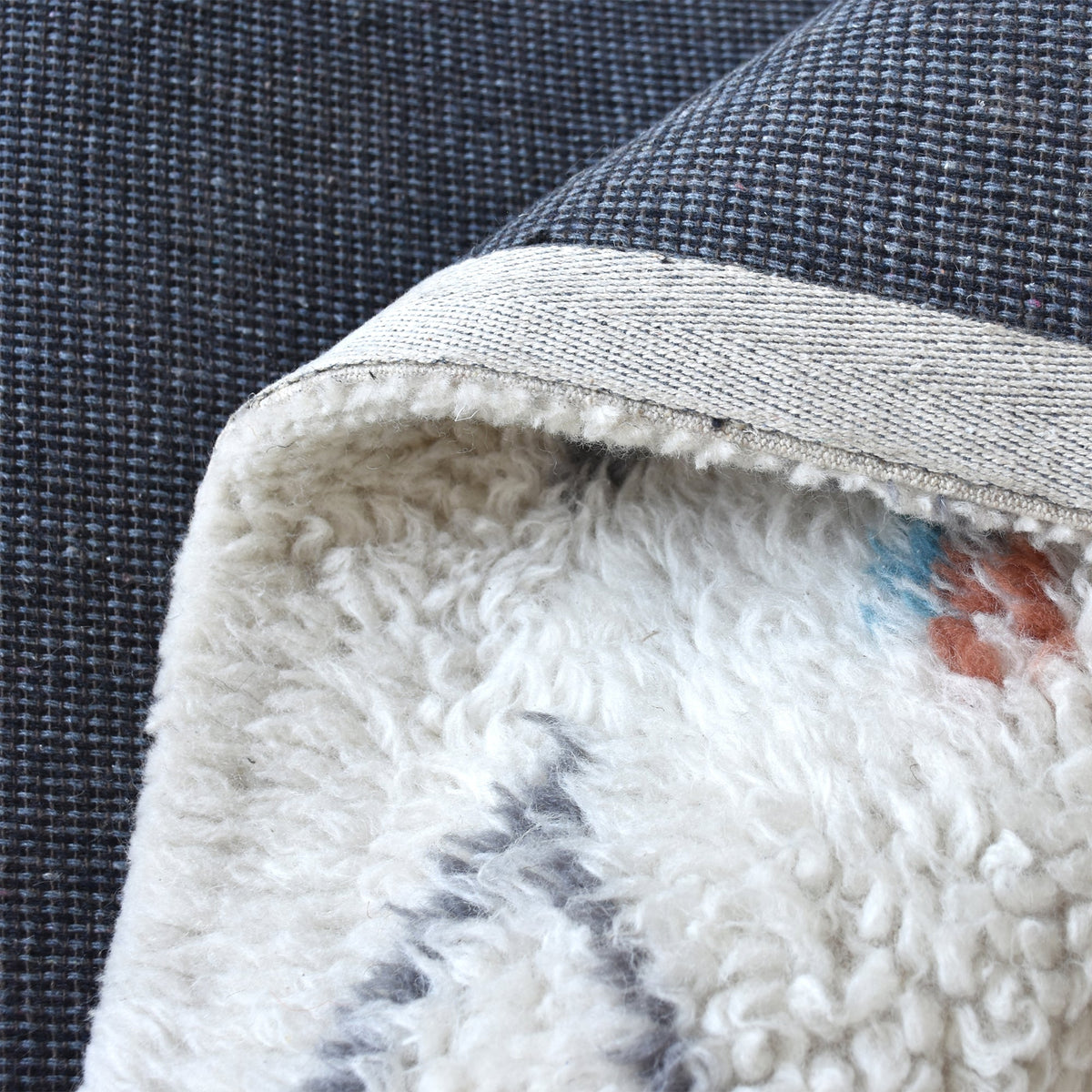 Mela tufted New Zealand wool rug with an ivory lattice and rust, teal and charcoal diamonds