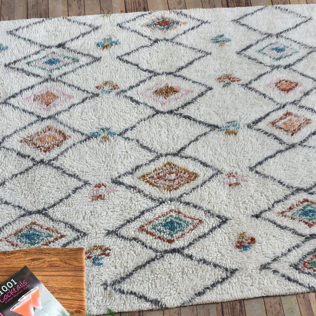 Mela tufted New Zealand wool rug with an ivory lattice and rust, teal and charcoal diamonds