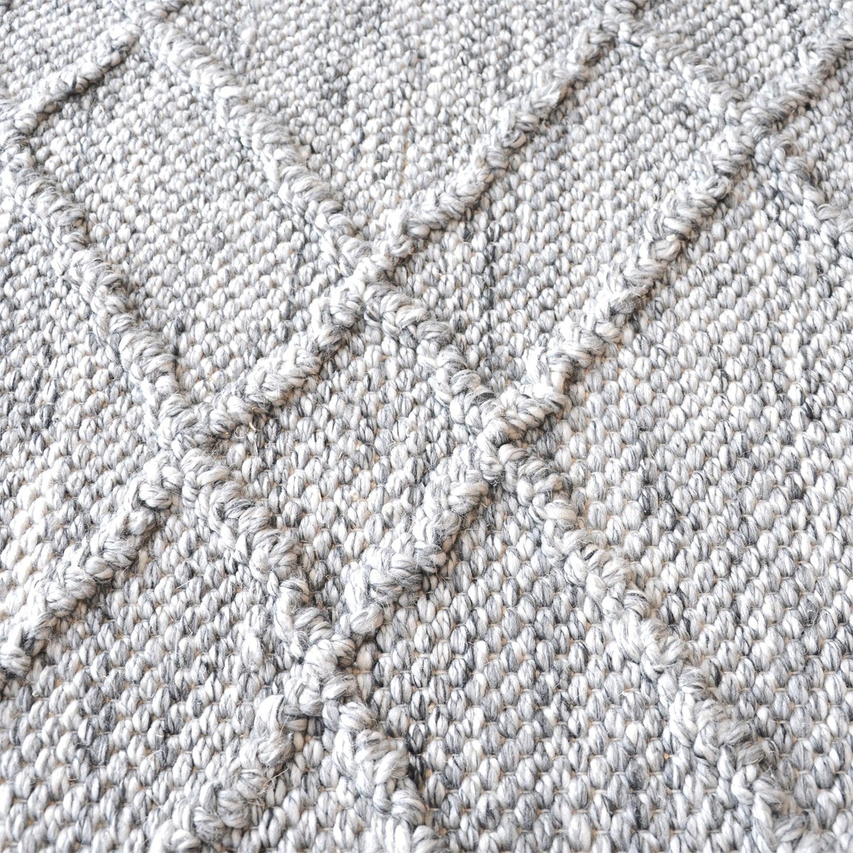 Razai handwoven recycled PET rug with a taupe diamond-quilted raised weave, on a patio