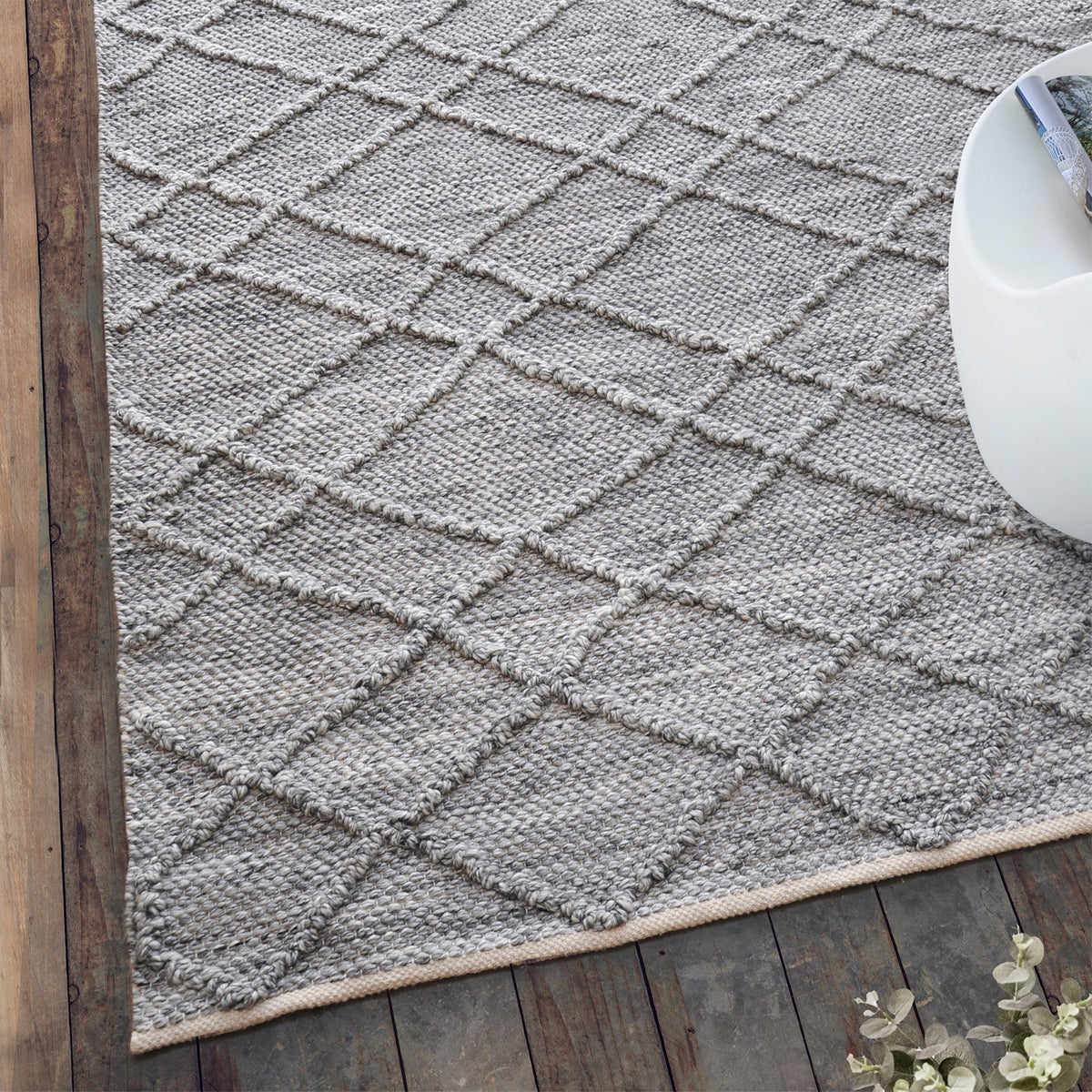 Razai handwoven recycled PET rug with a taupe diamond-quilted raised weave, on a patio