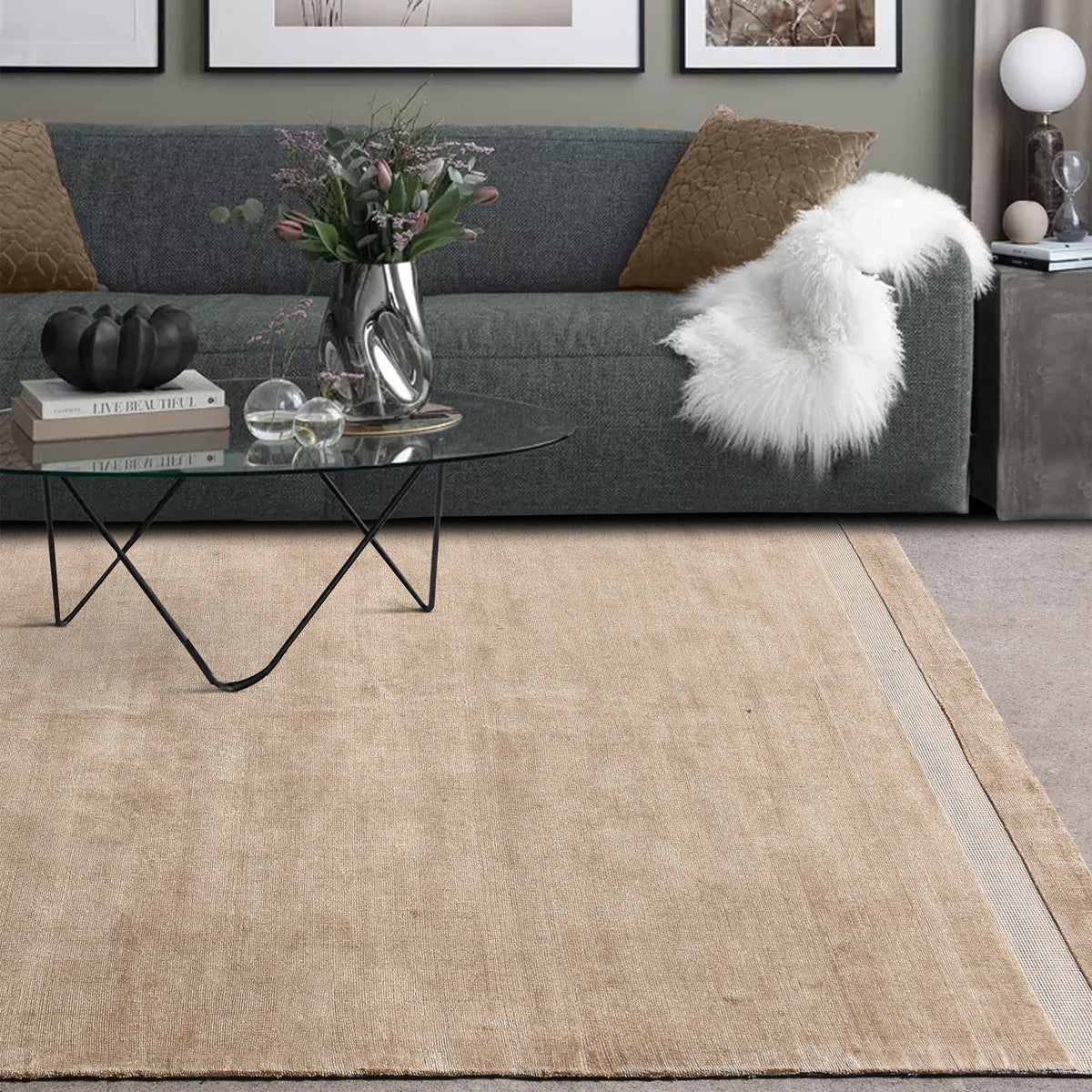 Chamak handwoven viscose rug in plain camel sand with a soft sheen, in a living room