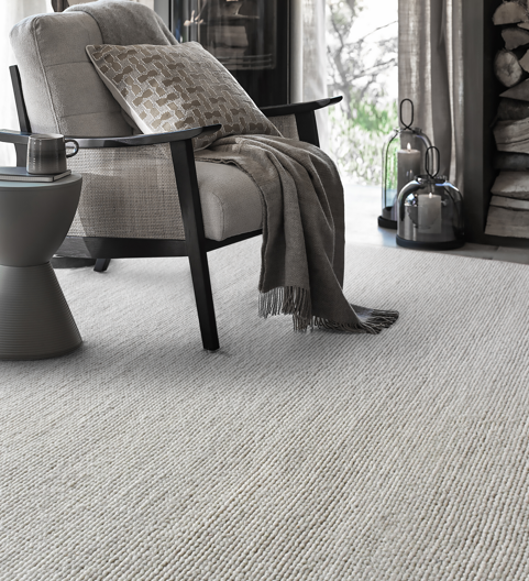Mist handwoven pale stone wool rug with a chunky looped weave, in a living room