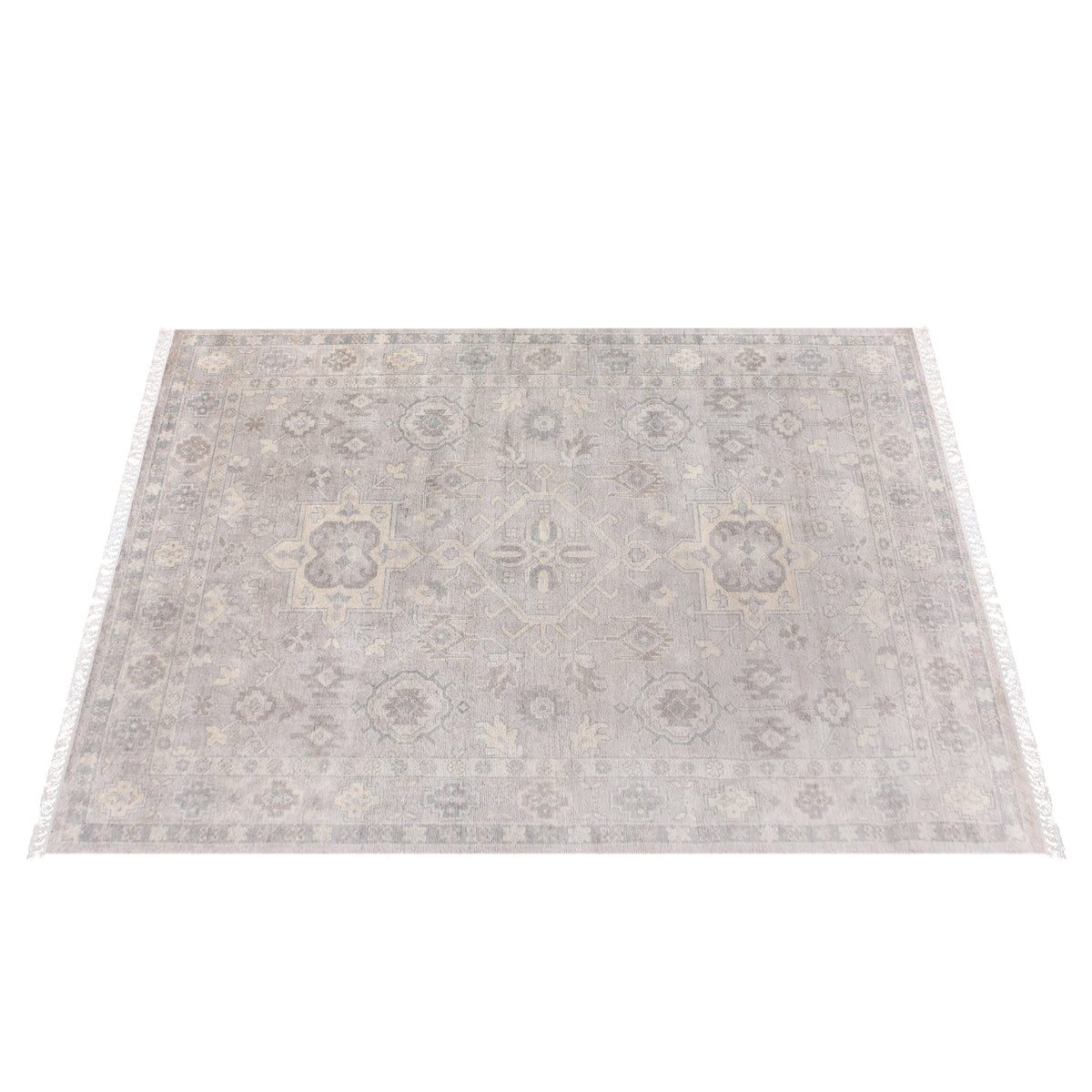 Yaad hand-knotted wool rug with distressed tribal medallions in pale taupe and rust, in a dining room
