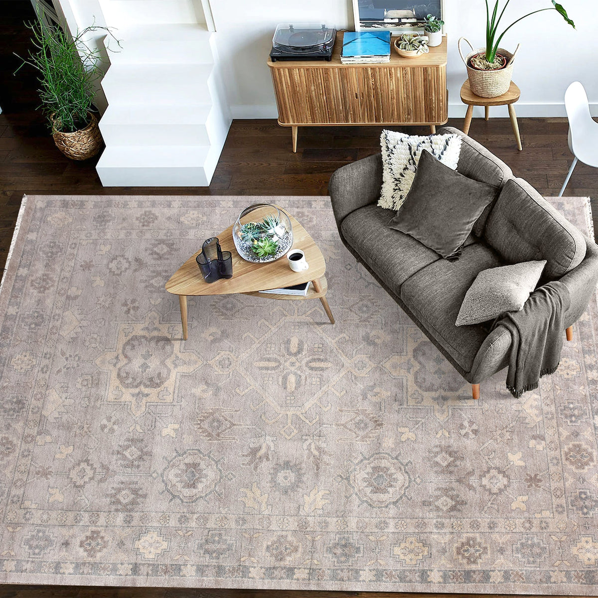Yaad hand-knotted wool rug with distressed tribal medallions in pale taupe and rust, in a dining room