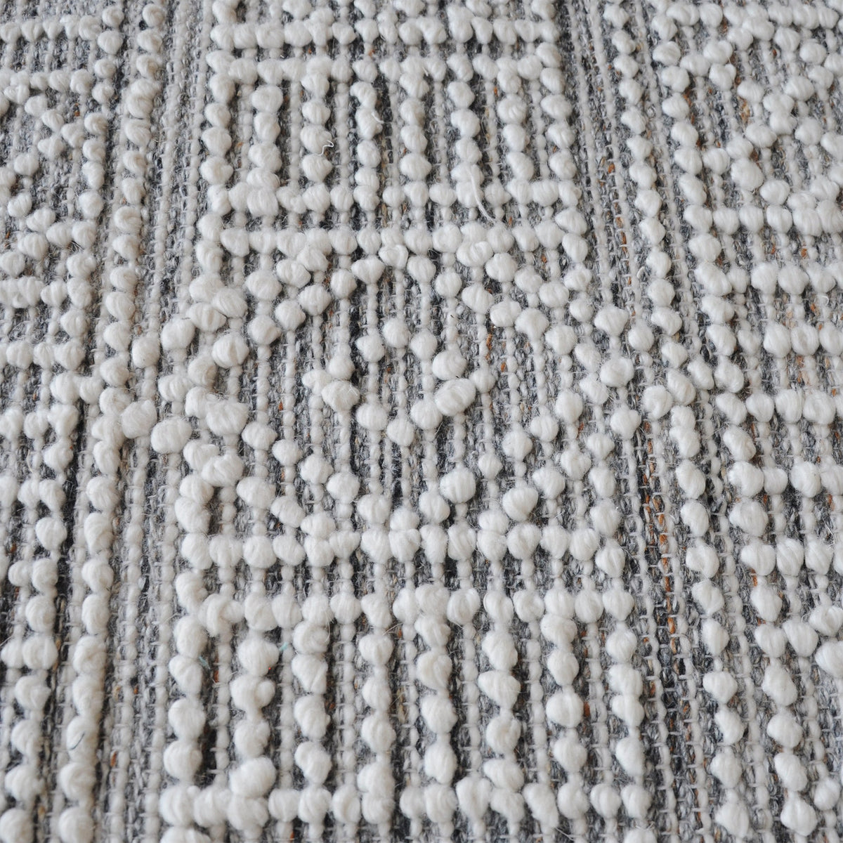 Baoli handwoven recycled PET rug with chunky ivory and grey tribal geometry, in an entryway