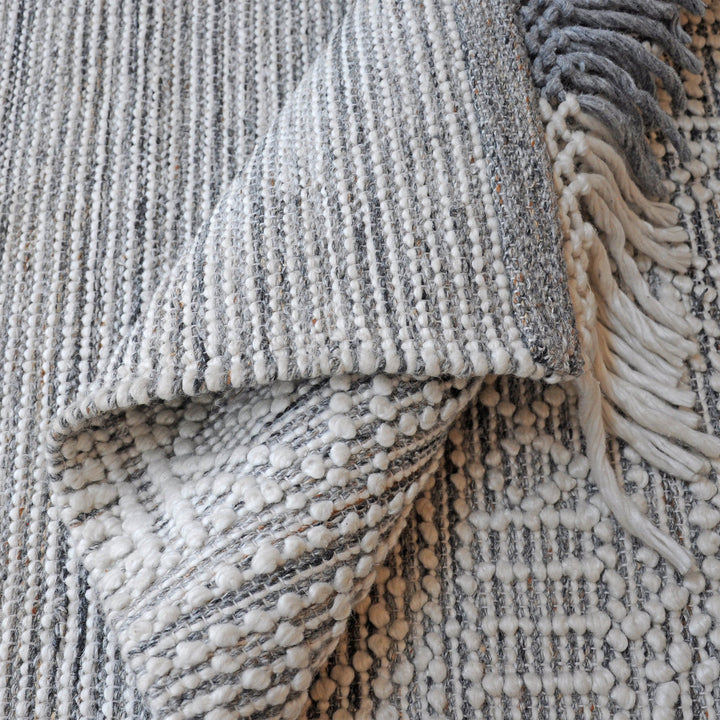 Baoli handwoven recycled PET rug with chunky ivory and grey tribal geometry, in an entryway