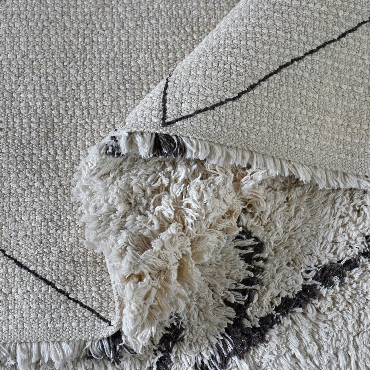 Lipi tufted cotton shag rug in ivory with a bold black lattice, in a bedroom