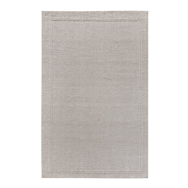 Linen handwoven wool rug in plain cream with a tonal border, in a bedroom