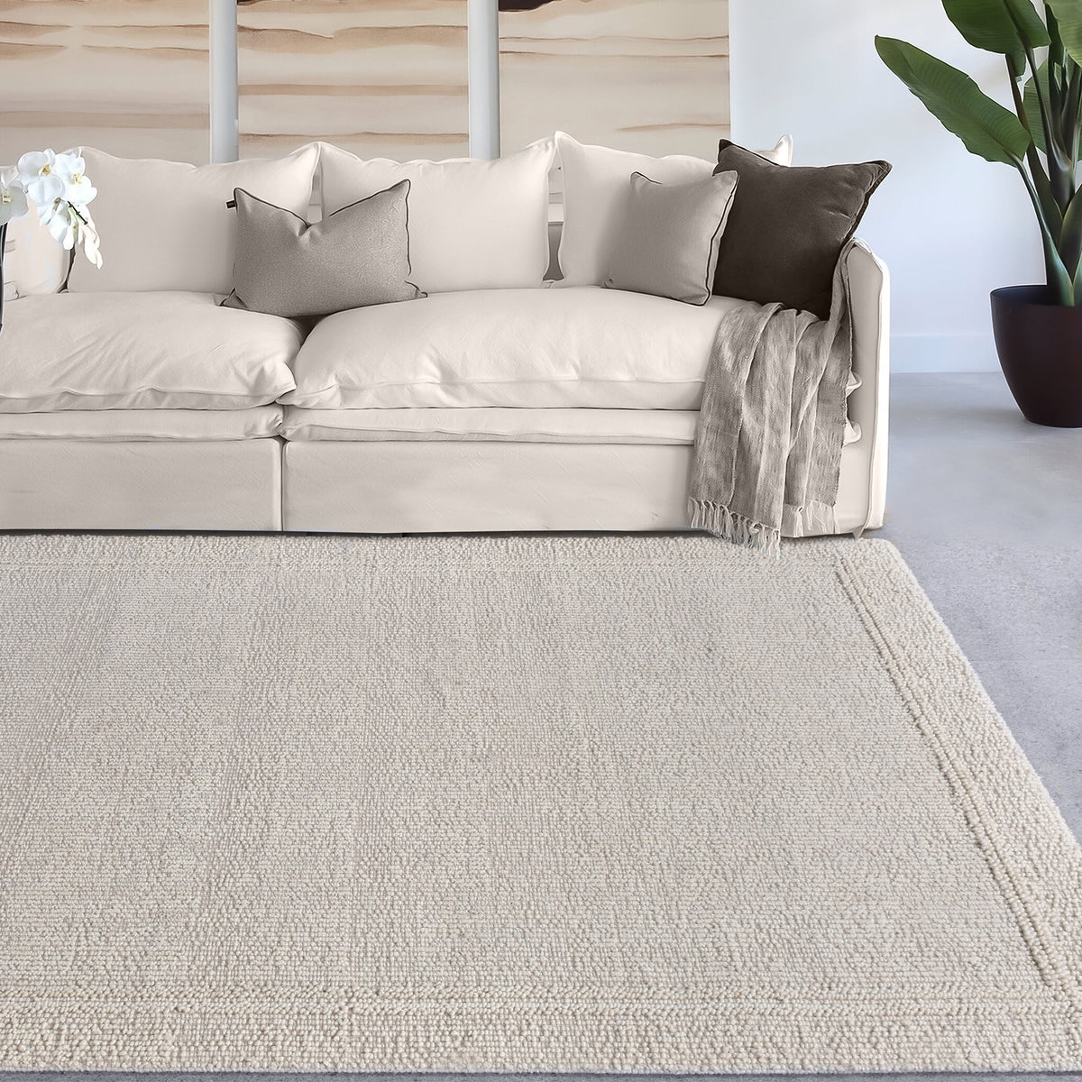 Linen handwoven wool rug in plain cream with a tonal border, in a bedroom