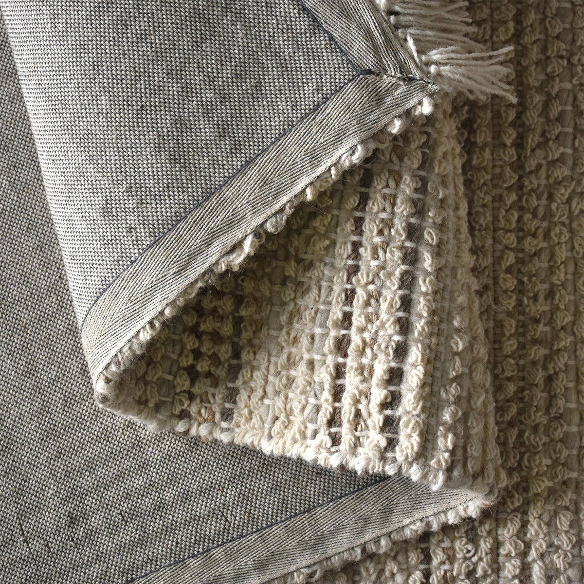 Kinara handwoven wool and jute rug in ivory and beige stripes, in a living room