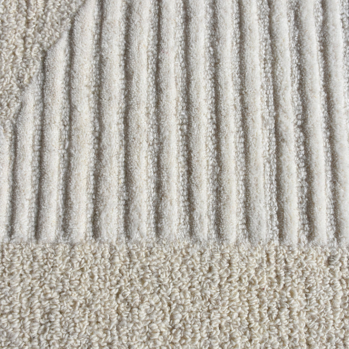 Archway handwoven ivory wool rug with carved arc lines, in a living room