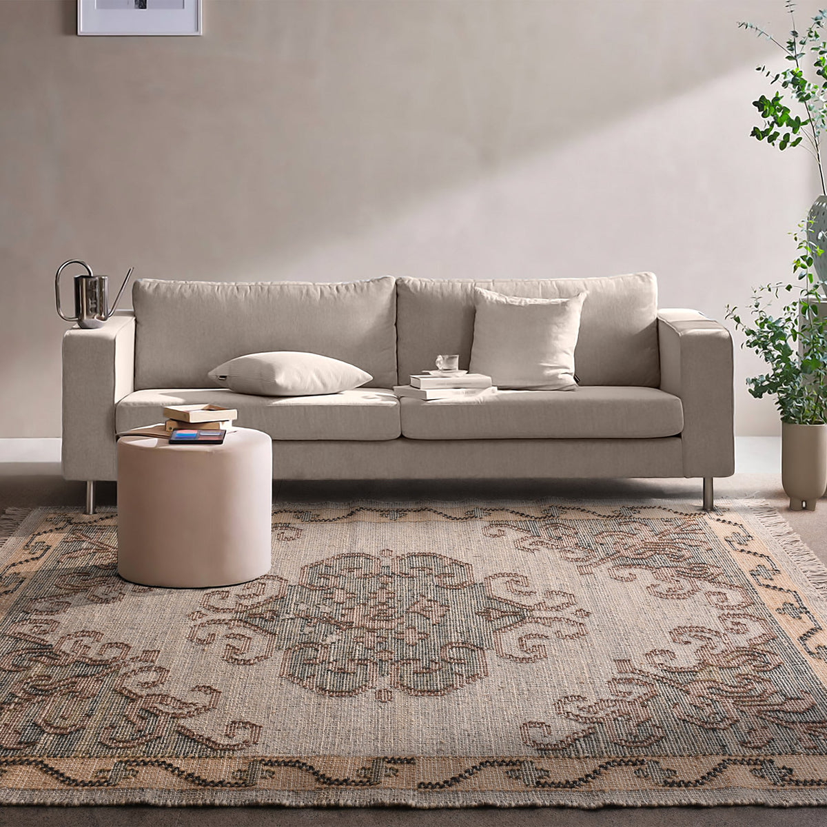 Haveli handwoven flatweave jute and wool rug with a faded beige medallion and terracotta border, in a living room