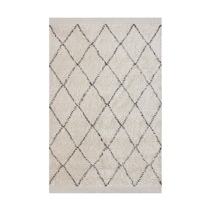 Syahi handwoven wool rug with a charcoal diamond lattice on ivory, in a study