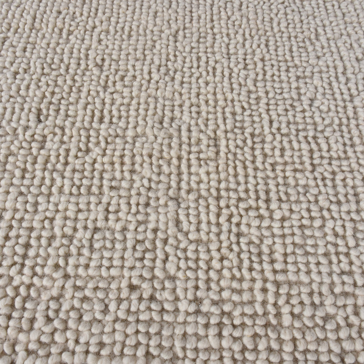 Lakeer handwoven ridged wool rug in oatmeal, tone on tone, in a bedroom