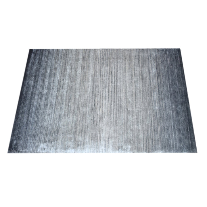 Baadal handwoven wool and viscose rug in streaked grey, charcoal and silver, in a living room