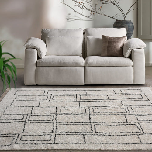 Eent tufted cotton rug with charcoal rectangle grid on ivory, in a bedroom