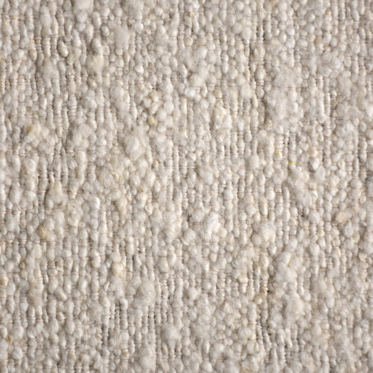 Kinari handwoven wool and jute rug in pale ivory with plain ribs and a tonal border, in a living room