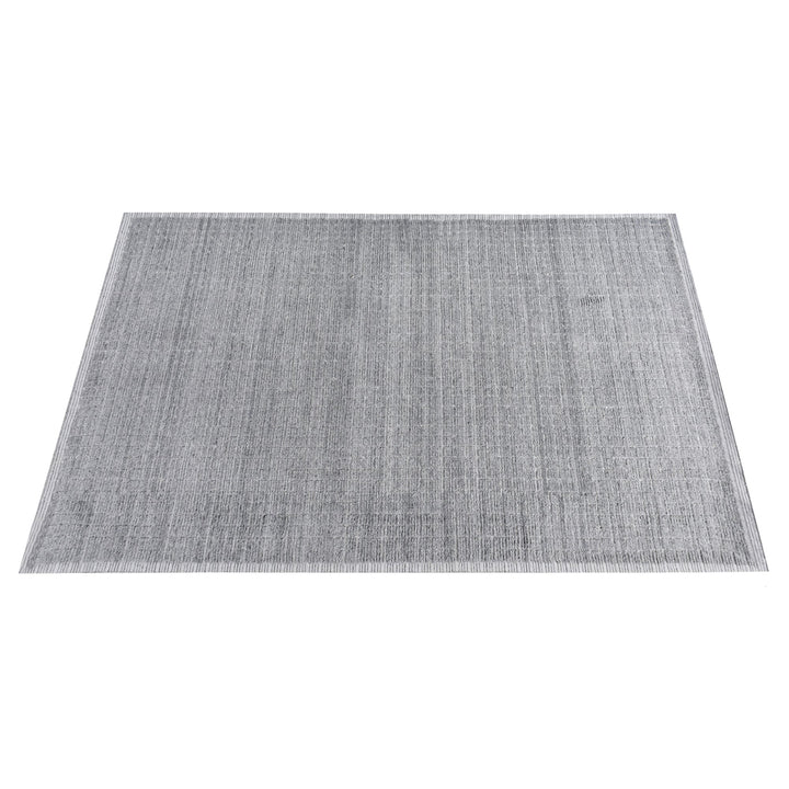 Raakh handwoven flatweave recycled PET rug in plain heather grey with fringe, in a living room