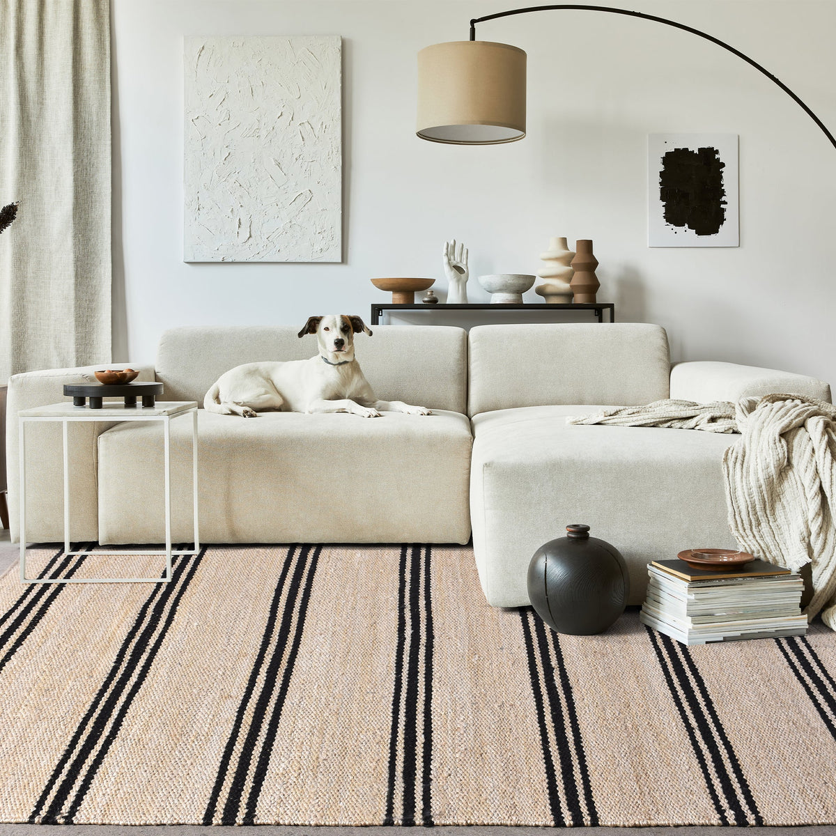 Khaat handwoven natural jute rug with black stripes, in a living room