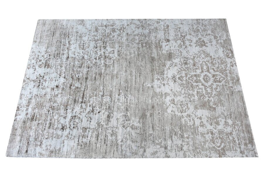 Parchhai handwoven viscose rug with an erased medallion on pale silver beige, in a living room