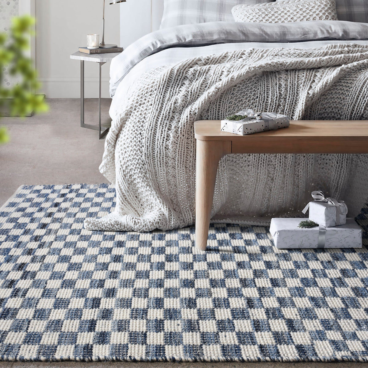 Taash handwoven denim and cotton rug with a navy and ivory checkerboard, in a living room