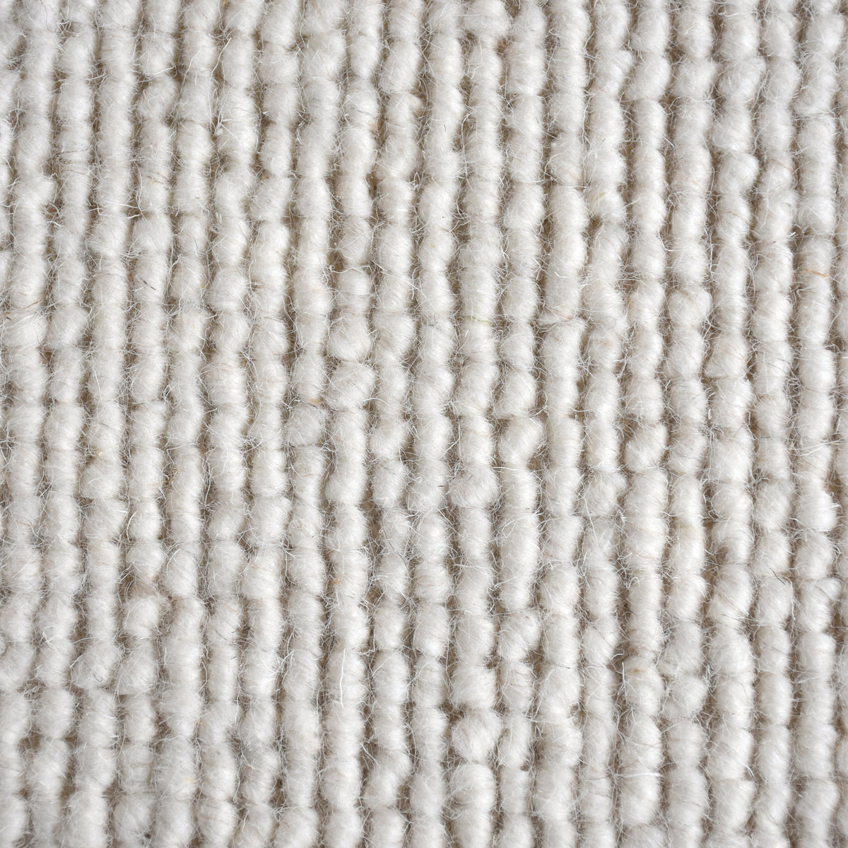 Mist handwoven pale stone wool rug with a chunky looped weave, in a living room