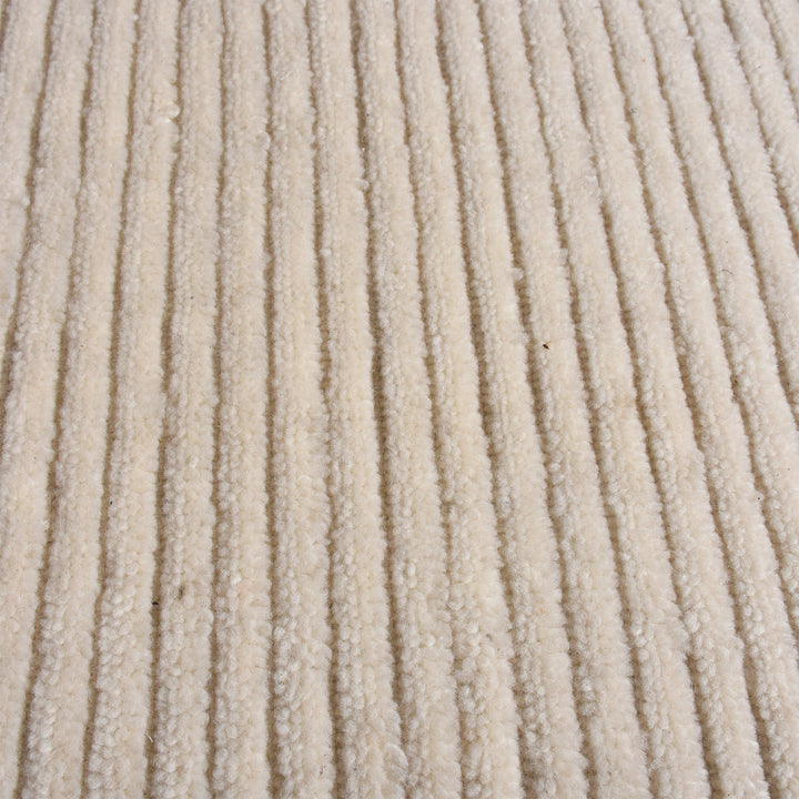 Hal handwoven NZ wool rug in ivory with wide ribbed stripes, in a dining room