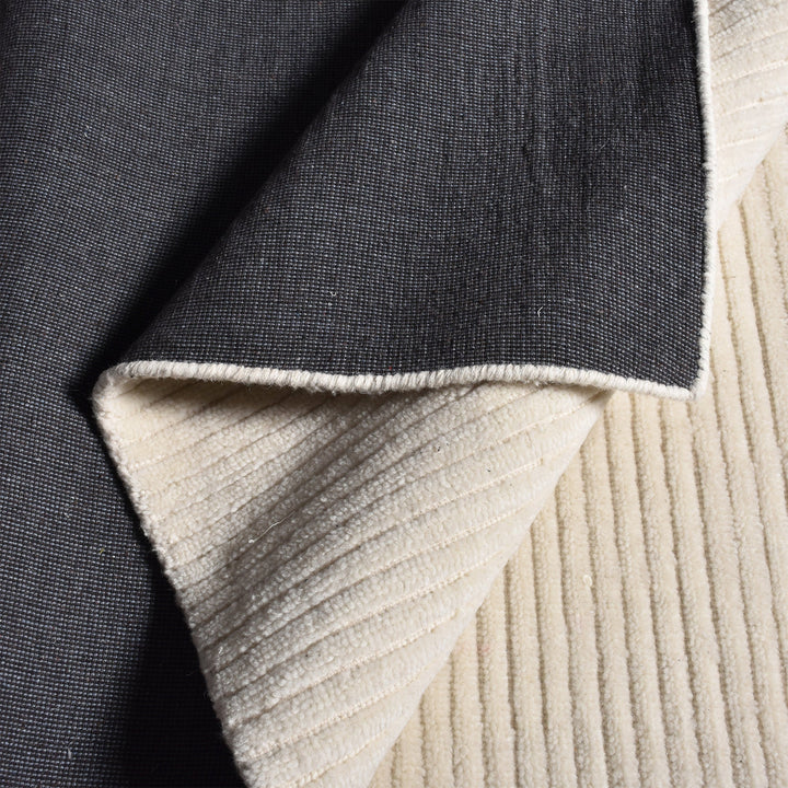 Hal handwoven NZ wool rug in ivory with wide ribbed stripes, in a dining room