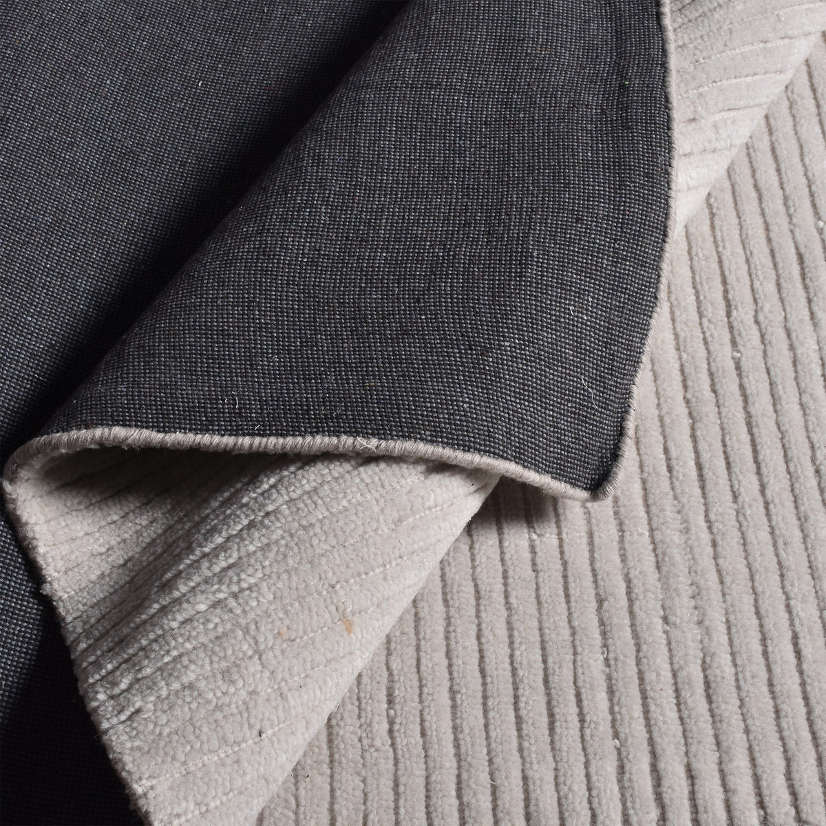 Megh handwoven NZ wool rug in light grey with wide ribbed vertical bands, in a living room